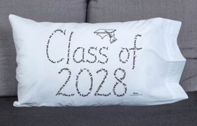 Class of 2028 written in hand-printed Bible verses in black ink on white pillowcase